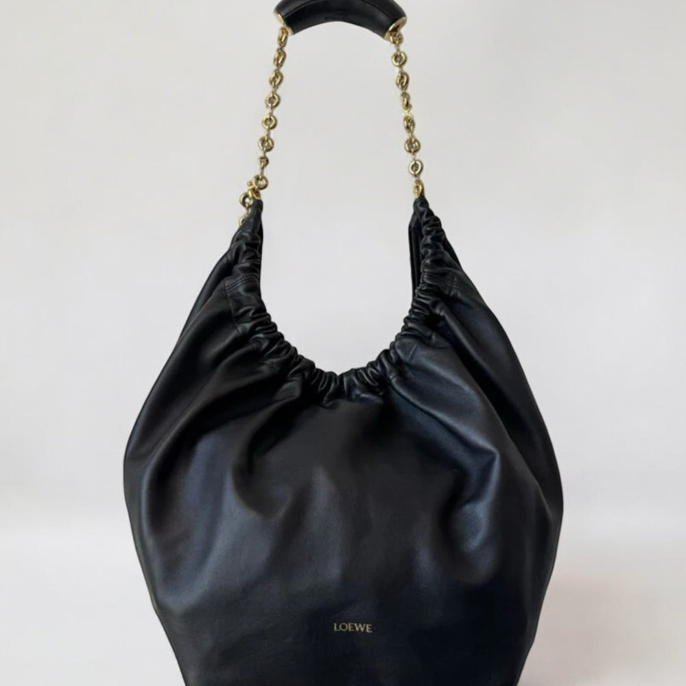 Black handbag with chain handle on a white background