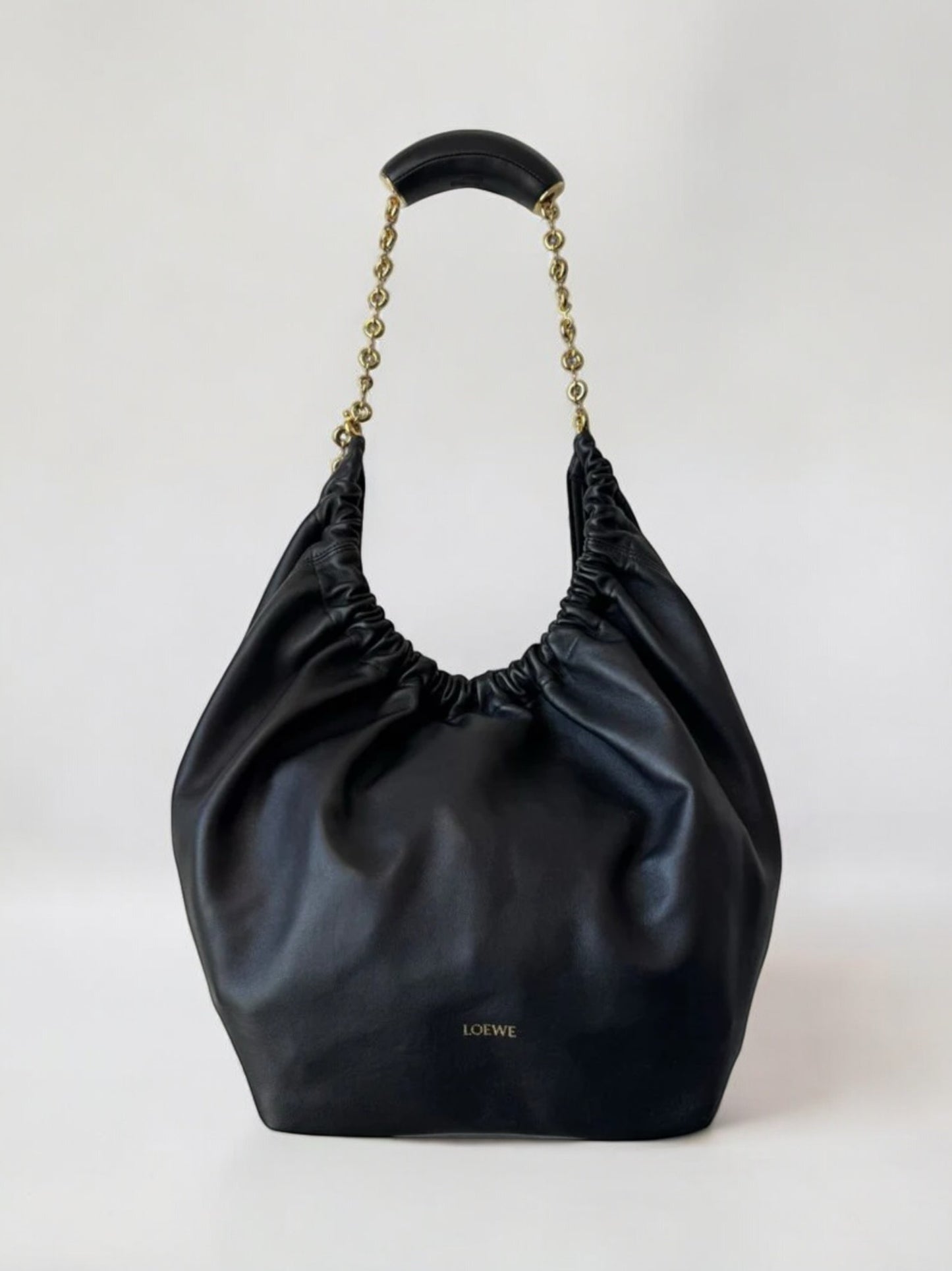 Black handbag with chain handle on a white background