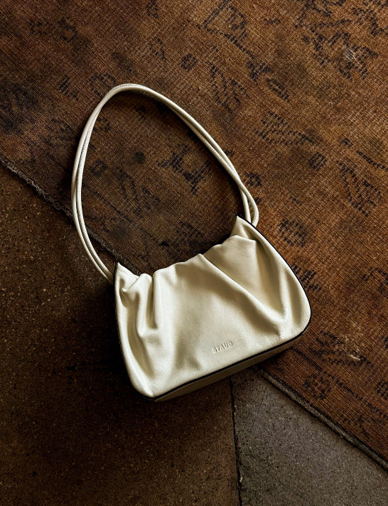 White handbag on a textured brown surface