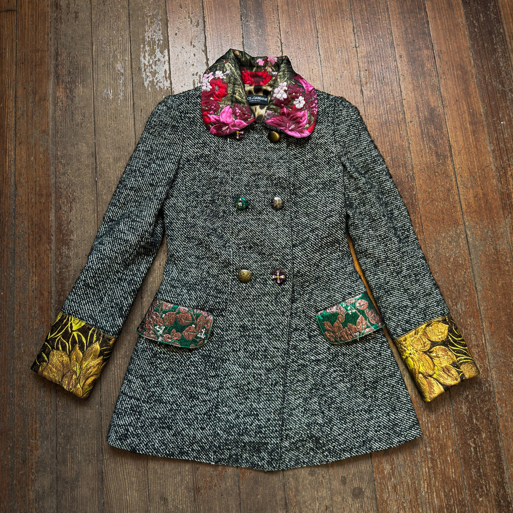Gray coat with floral and yellow accents on a wooden surface