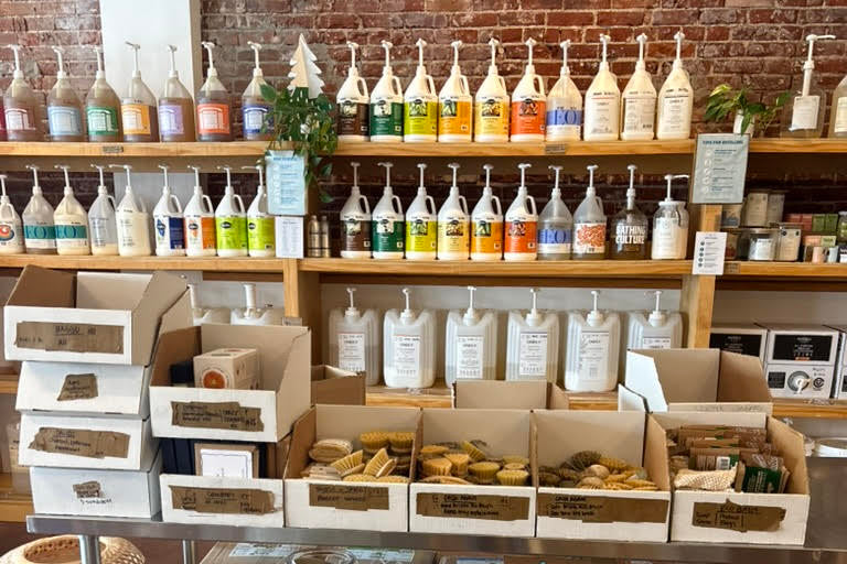 Display of laundry products and supplies in a store with shelves and boxes.